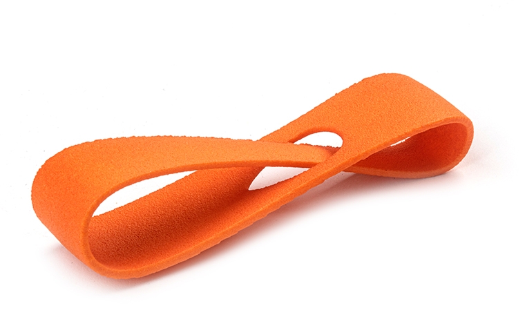 Un bucle naranja impreso en 3D, fabricado con PA 12 mediante sinterización láser, con un acabado teñido en color.