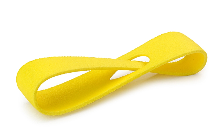 Eine gelbe 3D-gedruckte Schlaufe aus PA 12, die im Lasersinterverfahren hergestellt und farbig eingefärbt wurde.