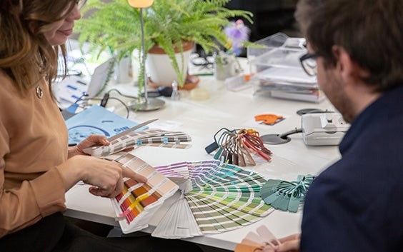 Des professionnels de la lunetterie assis à une table, examinant des échantillons de couleurs.