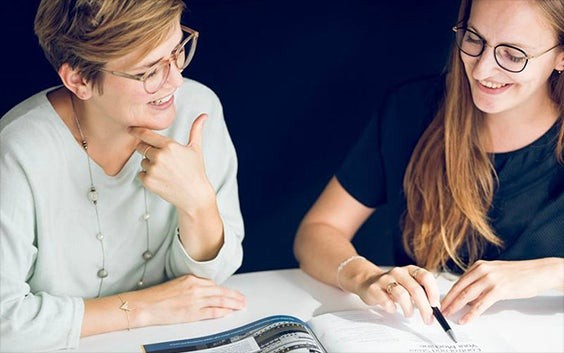 Deux collègues des ressources humaines discutent d'une brochure lors d'une réunion.