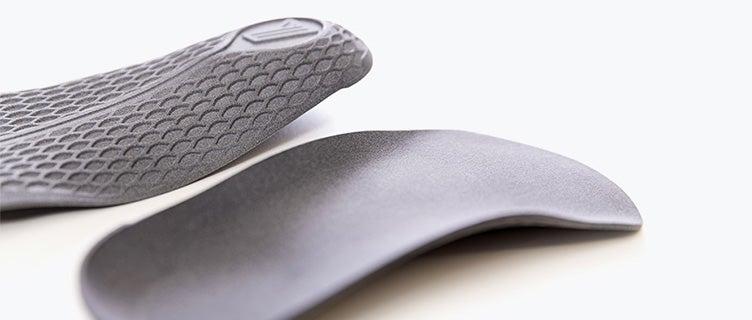 A pair of gray 3D-printed insoles made in PA 11 using Multi Jet Fusion.