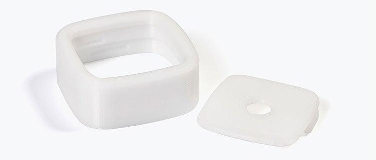 A white square and lid 3D printed in PC-ISO using fused deposition modeling.