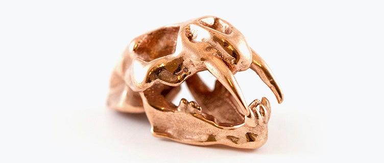 A model of a saber-toothed tiger skull made in copper using lost-wax casting.