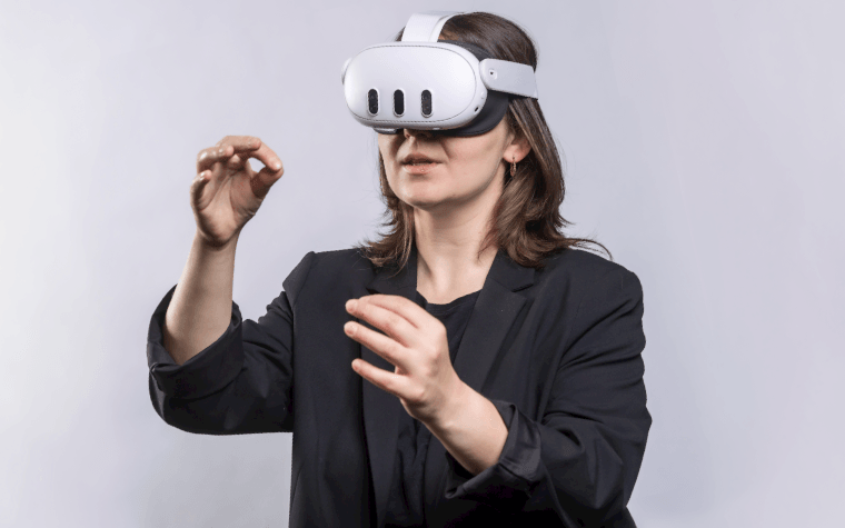 Une femme portant les lunettes Meta Quest 3 avec les mains devant elle.