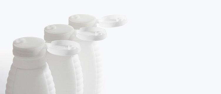 Row of honey bottles 3D printed in polypropylene with open snap lids