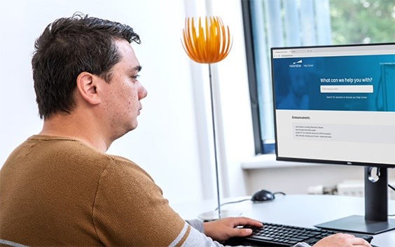 Man sitting at a desk in an office viewing the Materialise Help Center