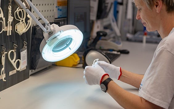 Person checking the quality of 3D-printed eyewear under a light