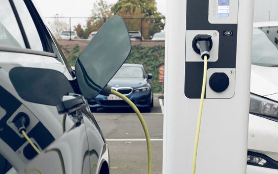 Car plugged into a charging station in a parking lot