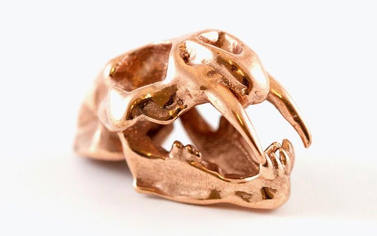A model of a saber-toothed tiger skull made in copper using lost-wax casting.