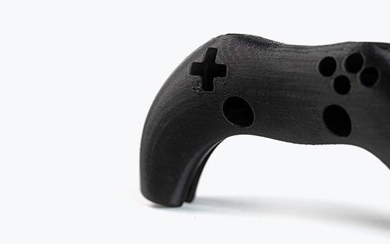 A black 3D-printed video game controller printed in ABS-ESD7 using fused deposition modeling.