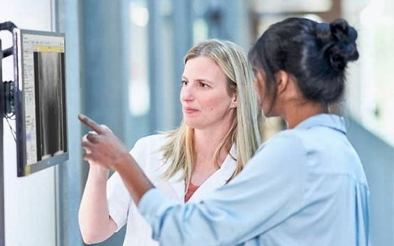 Two healthcare professionals looking at an X-ray on a screen