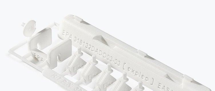 Une série de kits de réparation imprimés en 3D avec AESA 21.Labels de qualité J. Le kit contient des petites pièces en plastique blanc fabriquées en polyamide ignifugé, conçues par Expleo. Ces pièces sont utilisées pour remplacer les loquets couramment cassés sur les panneaux lambrissés des Boeing 737.