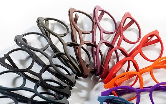 3D-printed eyewear frames in various colors lying in a circle