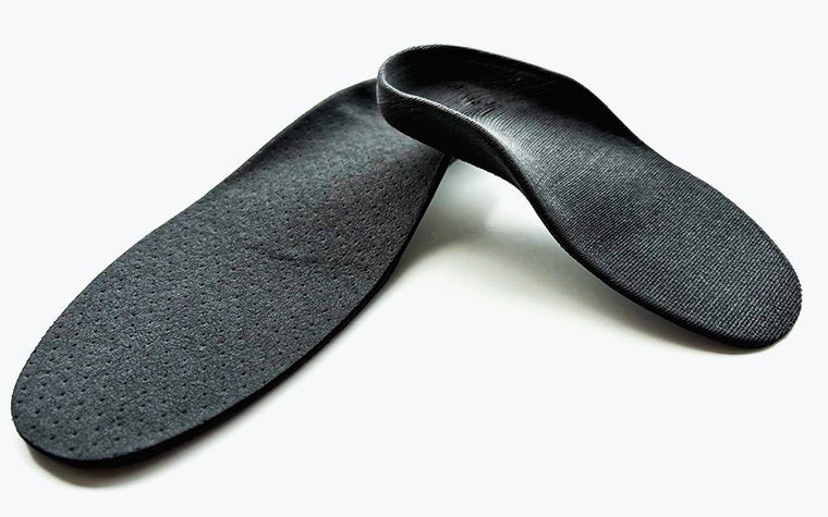A pair of black 3D-printed Phits Dynaprint insoles, made using fused deposition modeling.