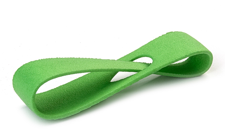 Un bucle verde impreso en 3D fabricado con PA 12 mediante sinterización láser, con un acabado teñido en color.