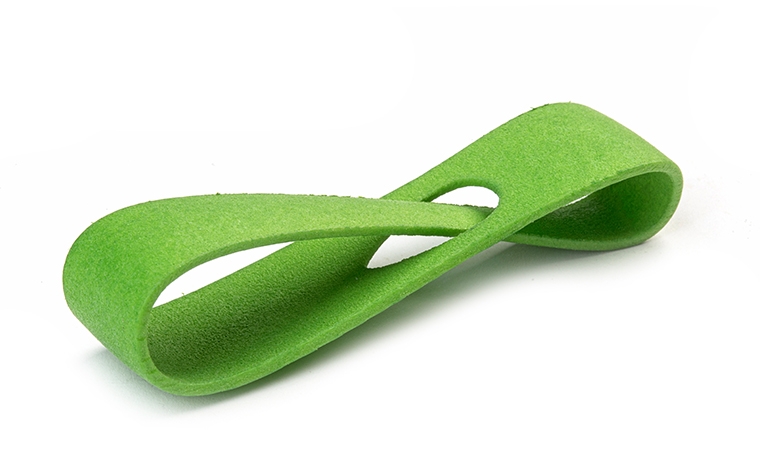 Un bucle verde impreso en 3D fabricado con PA 12 mediante sinterización láser, con un acabado suave y teñido de color.