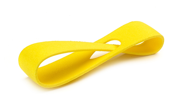 Une boucle jaune imprimée en 3D, réalisée en PA 12 par frittage laser, avec une finition lisse et colorée.