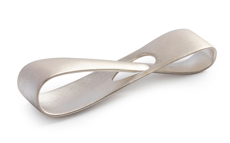 A silver infinity loop made with lost-wax casting and a corundum-blasted (matte) finish.